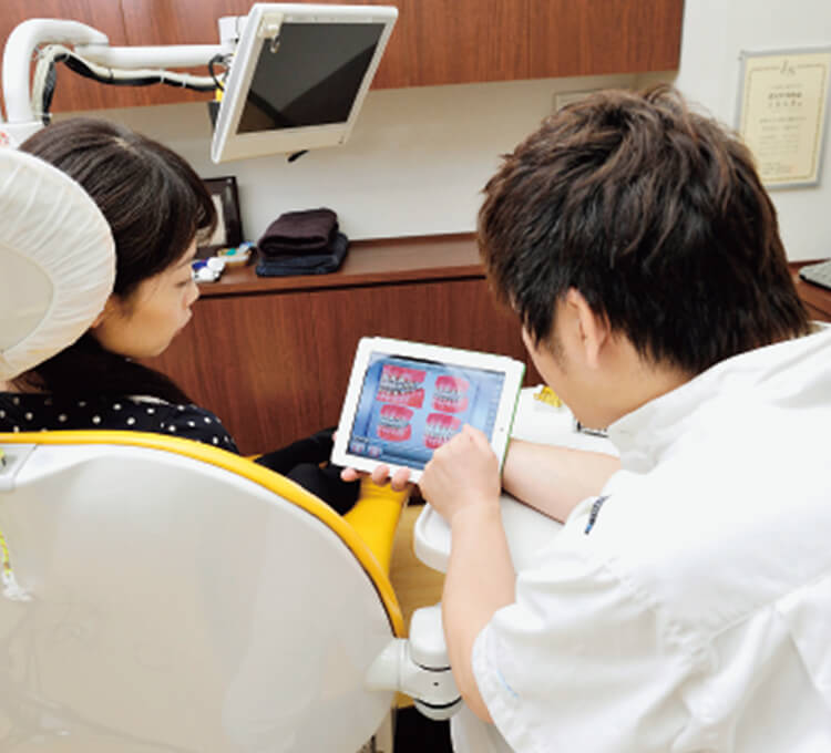 ウェブサイトを見た患者さんが来院すると、MedVisor Dental for iPadを用いて治療説明を行う。