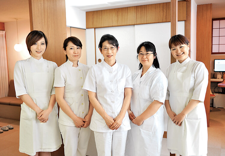 江崎院長をやさしく包む優美なスタッフたちの力強いアシスト。以心伝心のチーム医療が診療のクオリティを高めている。