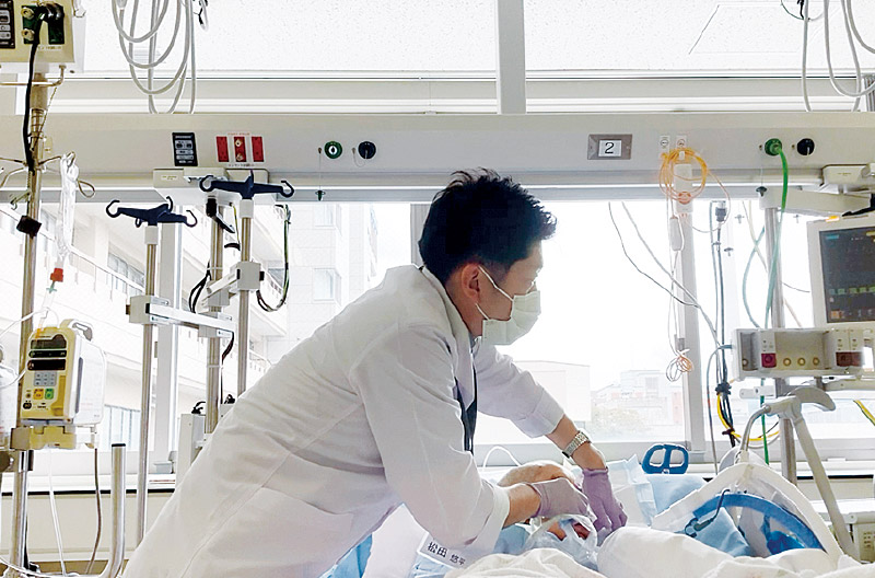 [写真] 周術期の患者さんに口腔ケアを行う松田先生