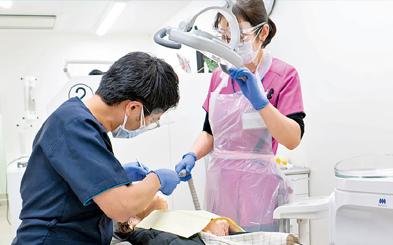 [写真] 診療室で抜歯を行う近石先生