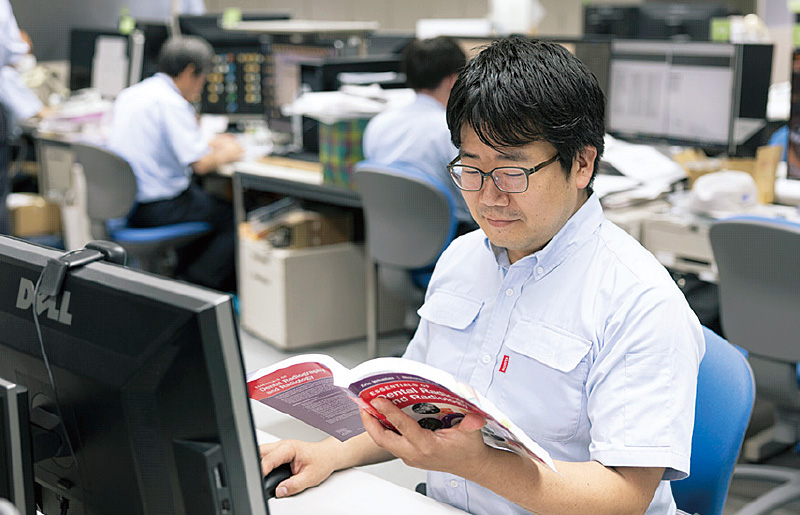 [写真] 文献に目を通す杉原さん