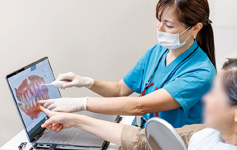 [写真] Primescan Connectで患者さんへ説明する様子